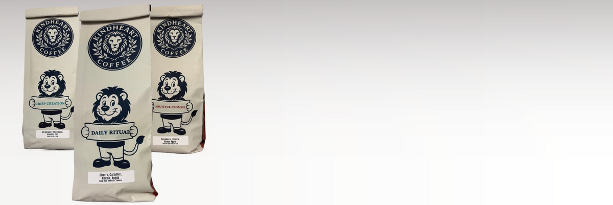 Three bags of coffee from Coffee Roasted by the Lion on a light gray gradient background. The bags are off-white with black and navy blue graphics of a lion wearing glasses and a circular logo.